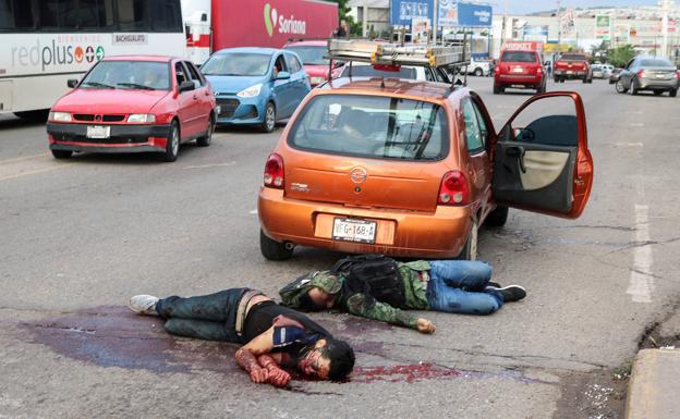Dos policías yacen en el suelo tras ser abatidos en la denominada 'batalla de Culiacán' en octubre del año pasado.