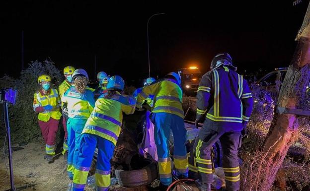 Los sanitarios y los bomberos rescatan los cuerpos del coche accidentado durante la madrugada del lunes, en Mostoles (Madrid)./EFE