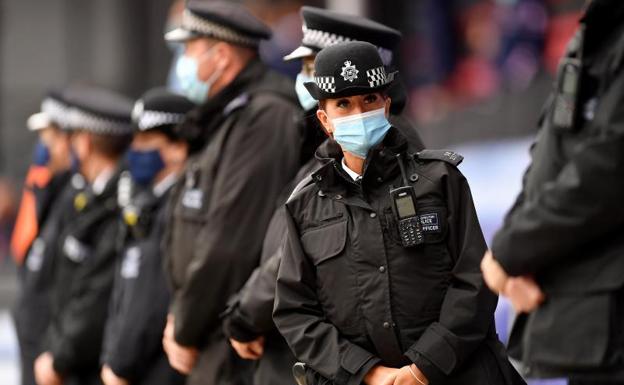 Policías británicos, sin armas, durante la vigilancia de un partido de fútbol en Londres./EFE