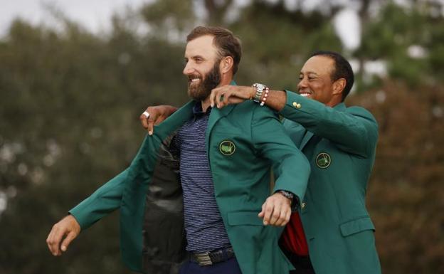 Tiger Woods enfunda a Dustin Johnson la chaqueta verde de campeón del Masters de Augusta. /Reuters