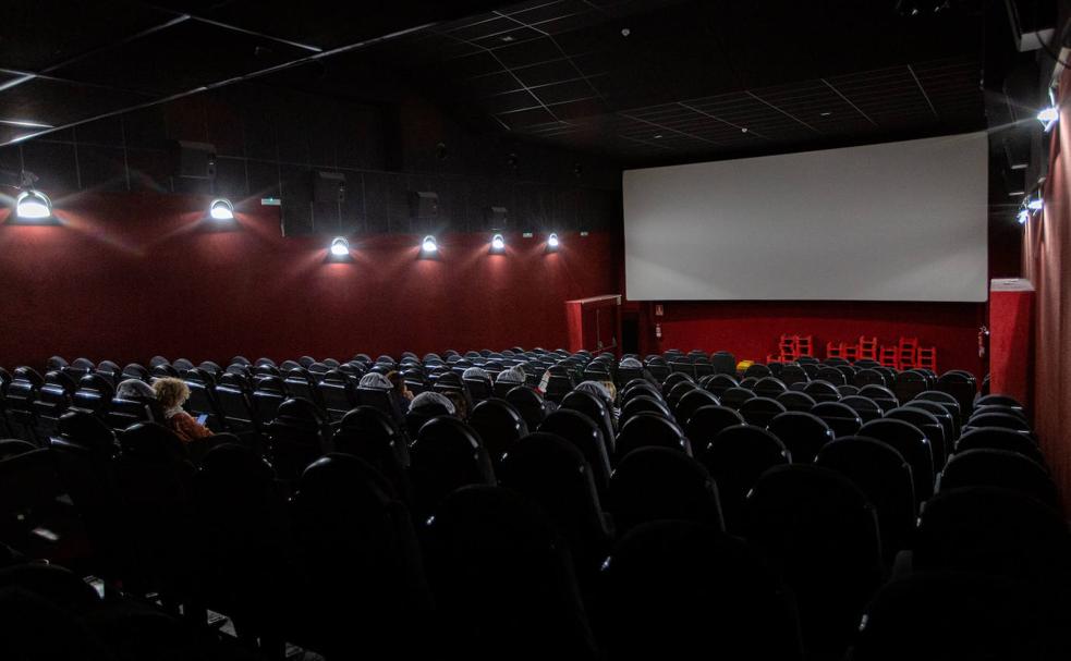 Varios espectadores esperan a que empiece la película, en una sala de cine de Vitoria./