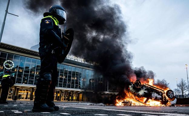 Incendio de un coche de policía en Eindhoven (Países Bajos) durante las protesta contra los toques de queda./AFP