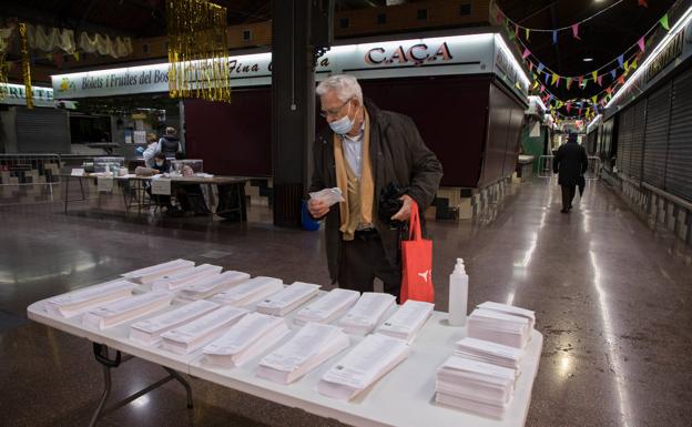 Un votante busca la papeleta antes de votar. 