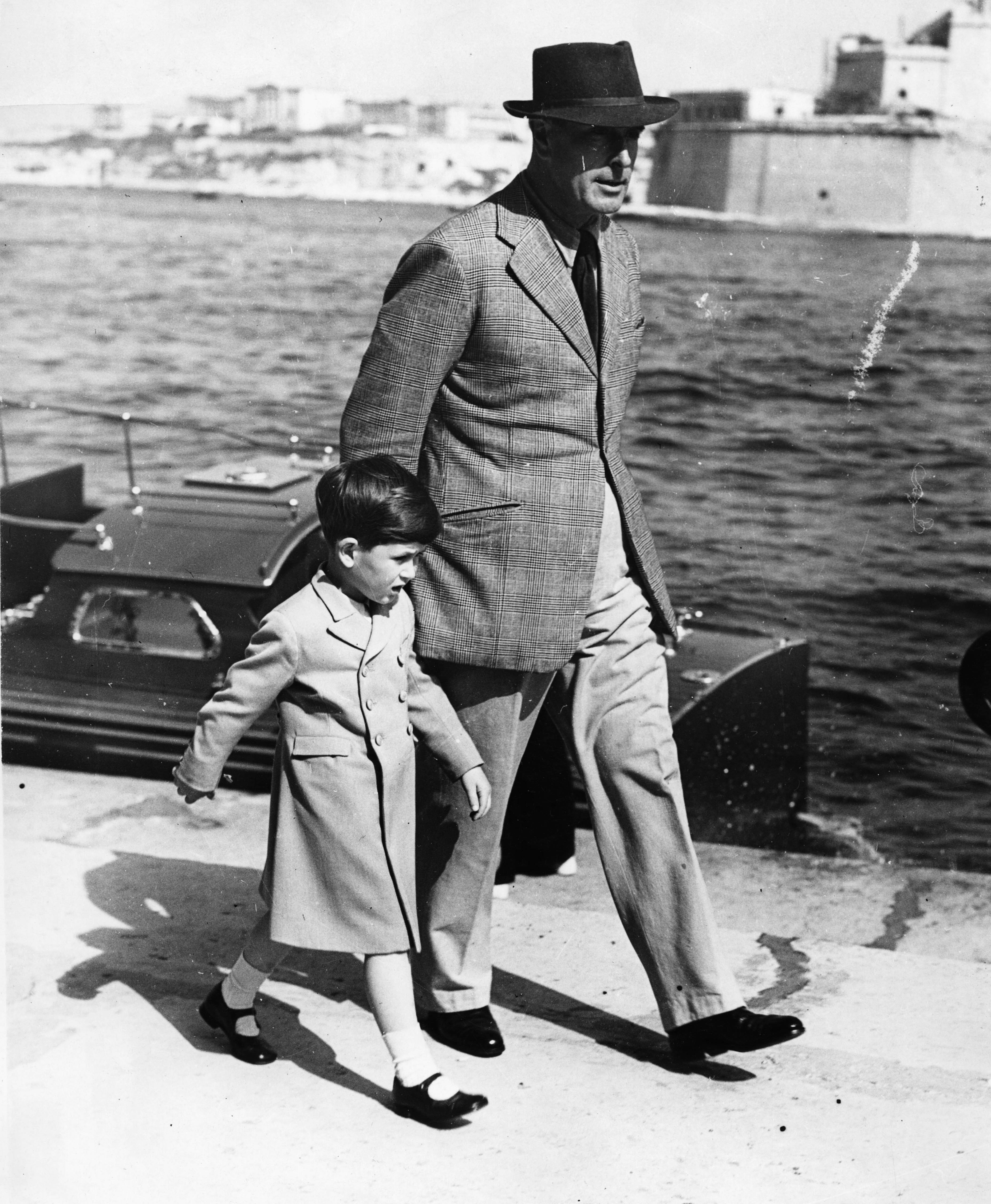 4 de abril de 1954. El príncipe Felipe camina con su hijo el príncipe Carlos a lo largo del muelle a su llegada a la isla de Malta.