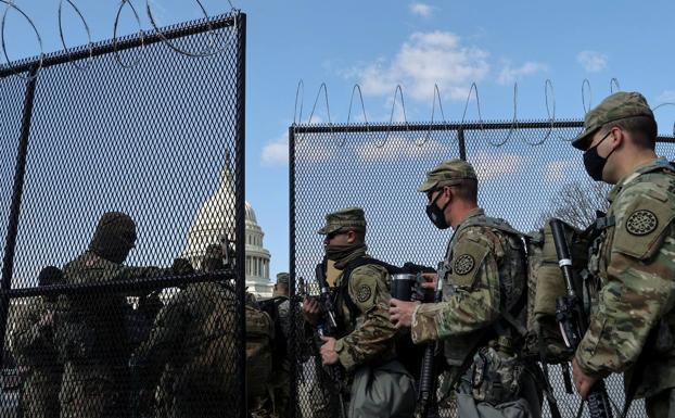 Los miembros de la Guardia Nacional vigilan los accesos vallados al Capitolio.