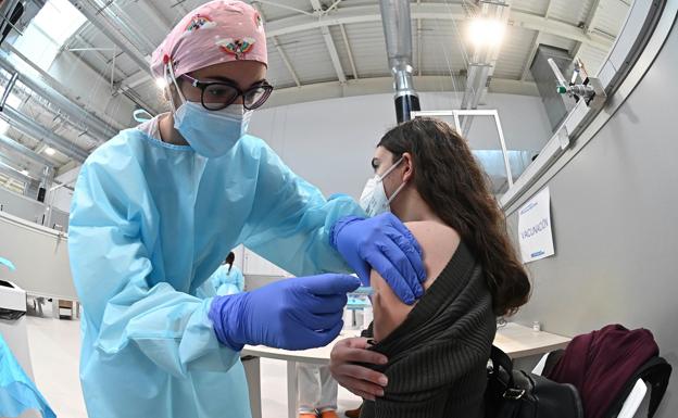 Una sanitaria pone la vacuna contra la covid-19 a una mujer en Madrid. /R. C.