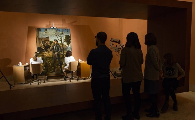 Un grupo de visitantes observa la restauración del cuadro, que se hizo de cara al público. /R. C.