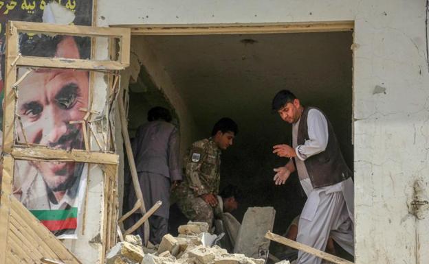 Funcionarios de seguridad afganos inspeccionan el lugar de la explosión de una bomba 