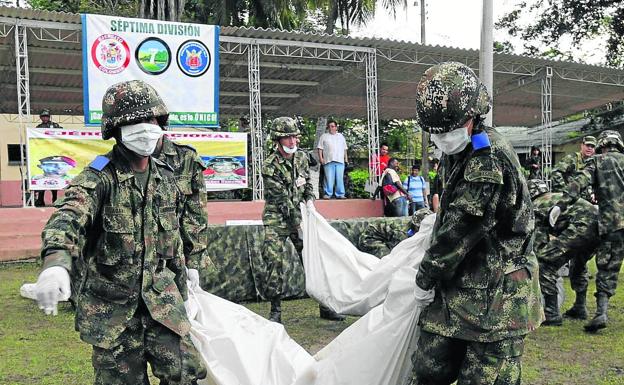 En esta imagen de 2008 soldados cargan los cuerpos de presuntos guerrilleros de las FARC abatidos.