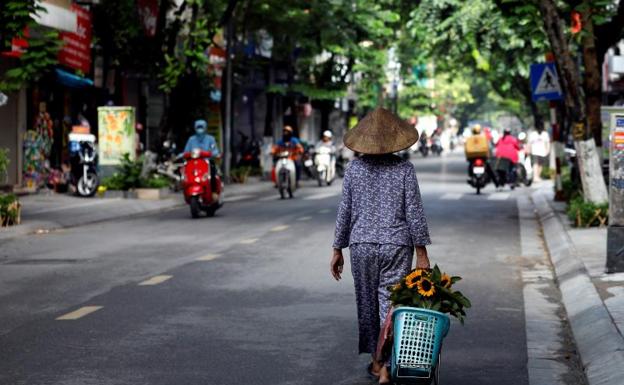 Una mujer pasea por una calle de Hanoi. /Efe