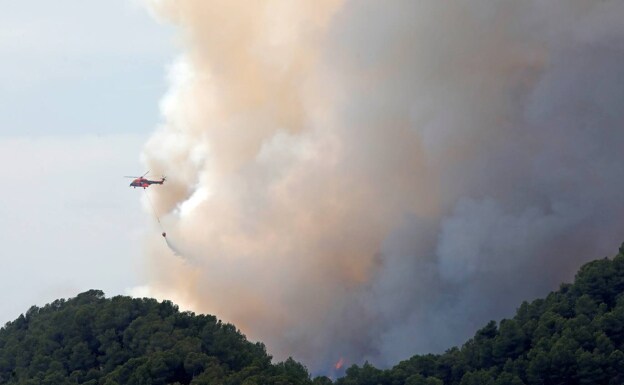 Un helicóptero interviene en la extinción de un incendios en la sierra de Santa María de Miralles. 