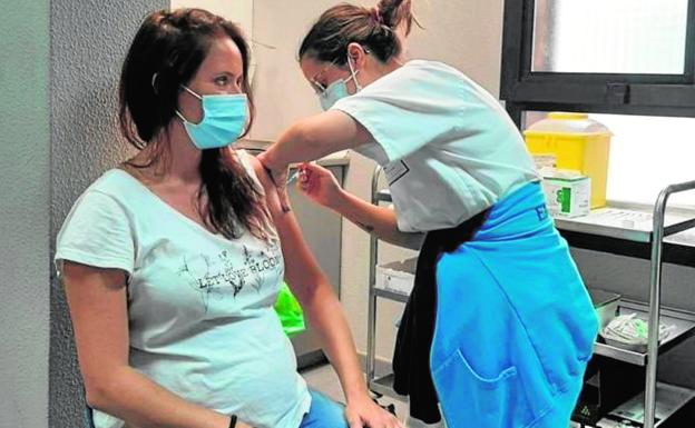Imagen de archivo de una sanitaria del Servicio Canario de Salud vacunando a una mujer embarazada en un centro sanitario. / C7