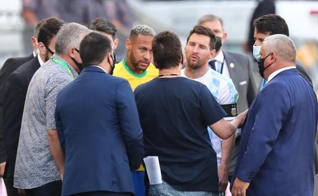 Leo Messi y Neymar Jr. conversan con miembros de Sanidad./ efe