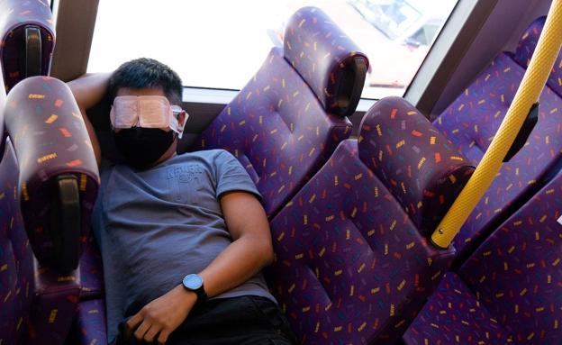 Un viajero descansa en el autobús del sueño de Hong Kong./AFP