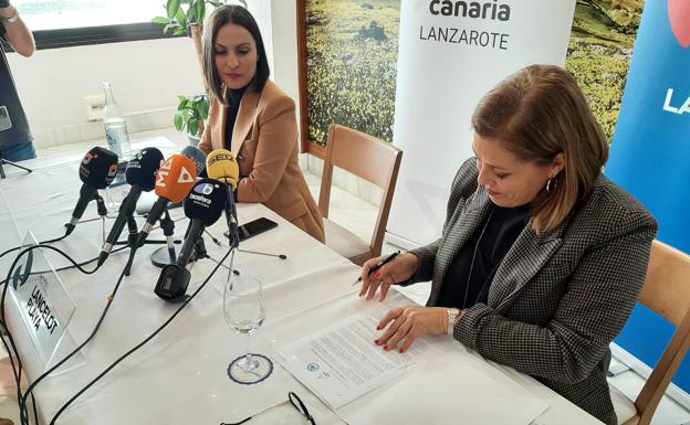 Firma del pacto en Arrecife entre Ástrid Pérez (PP), en primer término; y Migdalia Machín (CC). /CARRASCO