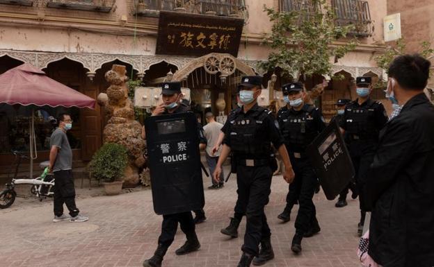 Policías patrullan una calle de la ciudad de Kashgar, en la región musulmana de Xinjiang./REUTERS