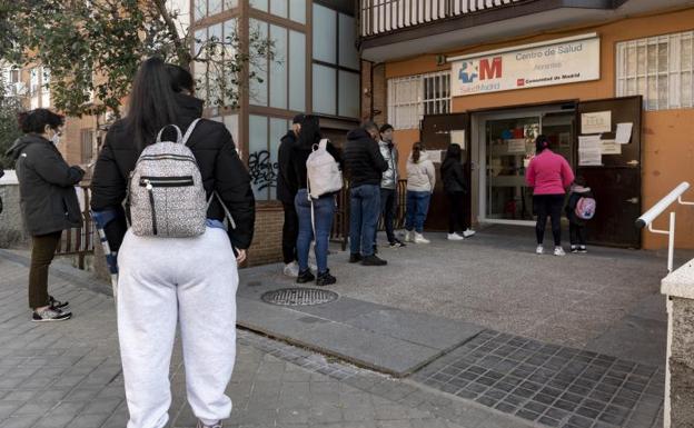 Un grupo de personas esperan en una fila en un centro de salud madrileño.