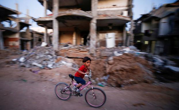 Un niño en bicicleta por las calles de Gaza. /Reuters