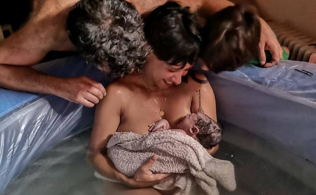 Aída Iglesias con su hijo y su pareja, después del parto. /C. Delgado