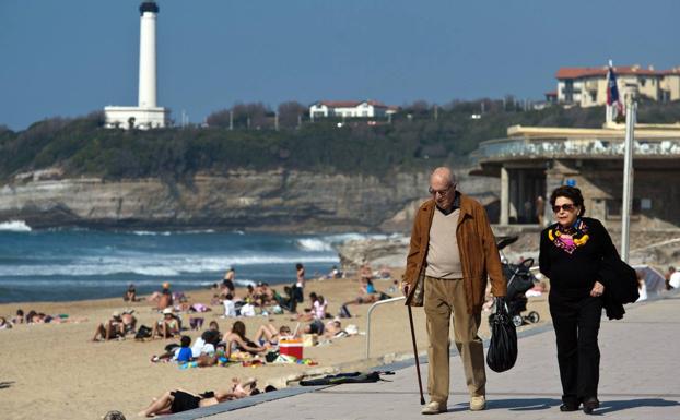 Dos jubilados pasean junto a una playa. /ARCHIVO