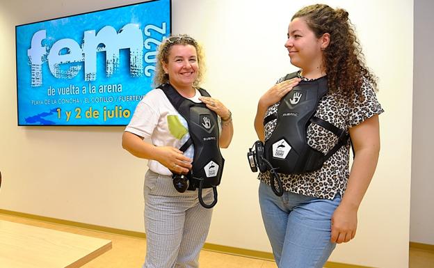 Dos usuarias de Fasican, con las mochilas auditivas que permitirán sentir las vibraciones de la música en el FEM. 