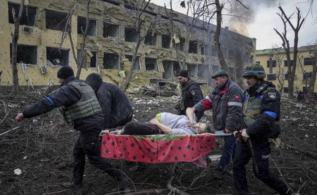 Mariúpol, donde pueden haber fallecido hasta 25.000 personas, ha sido una de las ciudades más castigadas desde el inicio de la guerra. En la imagen, evacuación de una mujer tras un ataque al centro de maternidad de la localidad /Evgeniy Maloletka