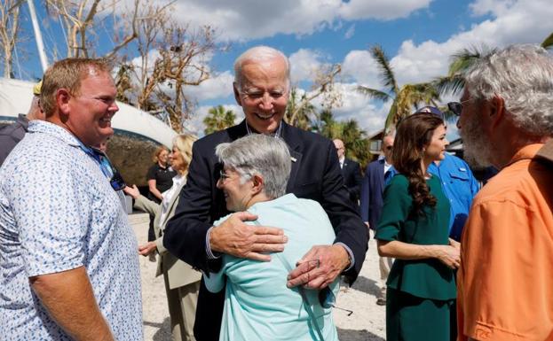 Biden abraza a una damnificada por el huracán a su llegada a Florida. 
