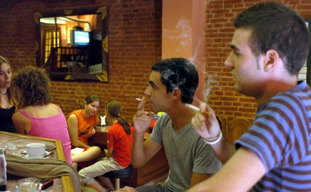 Un grupo de jóvenes fuma cigarrillos en un bar de Madrid. /EFE