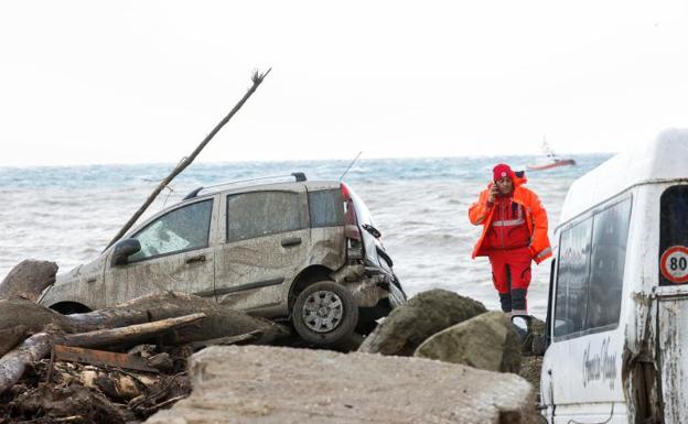 Un rescatista habla por teléfono cerca de autos dañados junto al mar, luego de un deslizamiento de tierra en la isla vacacional italiana de Ischia, Italia, 26 de noviembre de 2022./REUTERS/Ciro de Luca