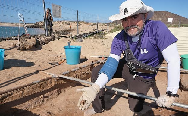 Ramón Cebrián, doctor en Historia, con una thais haemastoma (canaílla en Fuerteventura) que se acaba de encontrar en la zona de procesado de púrpura del yacimiento arqueológico Lobos I. 